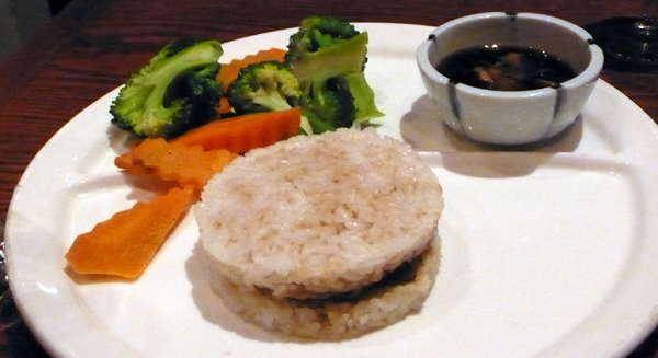 rice patty appetizer with vegetables and dipping sauce.