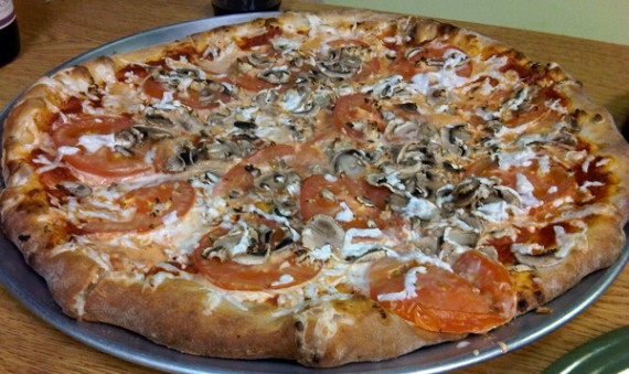 vegan pizza with teese cheese, tomatoes, mushrooms and garlic.