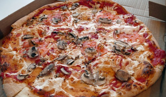 large pizza with mushrooms, tomatoes, garlic and teese vegan cheese.
