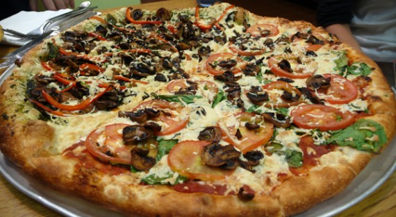 Large Vegan Pizza with Daiya Cheese: half Pesto, Field Roast Sausage, Peppers, Mushrooms and Basil. Half Mushrooms, Tomatoes, Basil and Chopped Garlic.