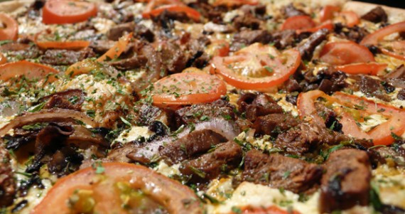 vegan cheesesteak pizza: gardein steak strips, carmelized onions, sauteed mushrooms, tomatoes, oregano.